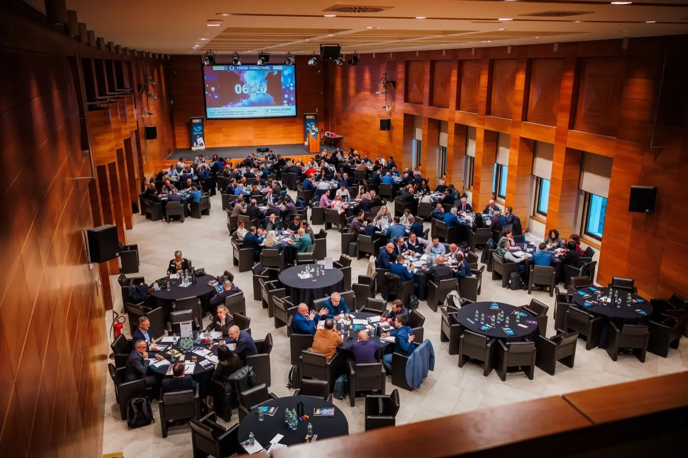 La sala del Forum Connections di San Marino vista dall'alto: una trentina
                        di tavoli rotondi occupati da imprenditori e professionisti che parlano fra loro